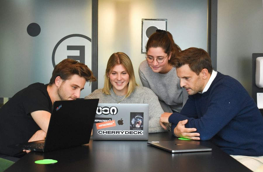 Four people working through a course together around a laptop
